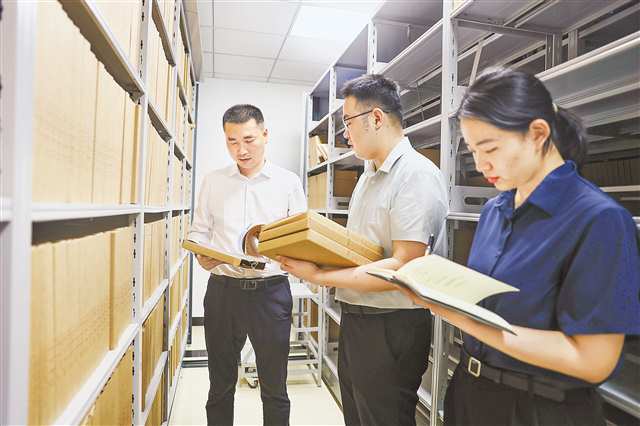 万东东（左一）与同事整理档案。（合川区纪委监委供图）