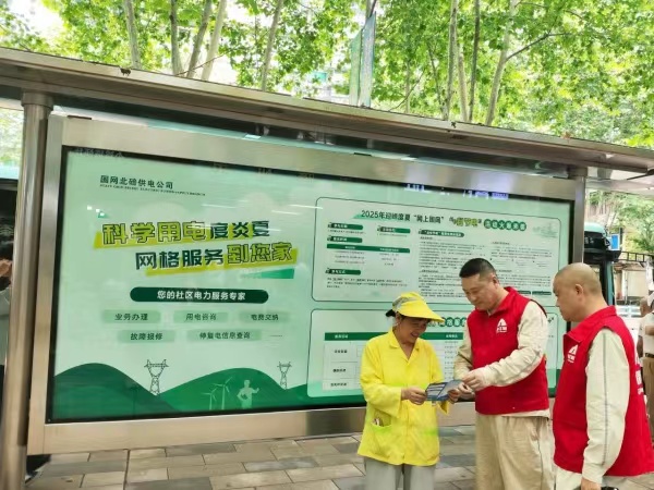 工作人员在公交站台为市民宣传科学用电知识。张强摄