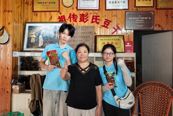 服務隊成員與彭氏豆干傳承人合影。重慶財經學院供圖
