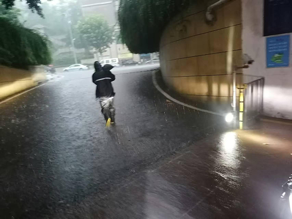 招商依雲江灣物業工作人員正緊急運送防汛沙袋封堵車庫入口，防止雨水倒灌。招商積余重慶公司供圖