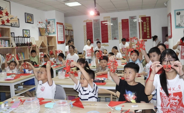 實踐團成員與孩子們共同創作剪紙作品。重慶師范大學美術學院供圖