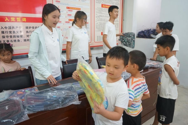 服務團成員給小朋友發放紀念品。李思諺攝