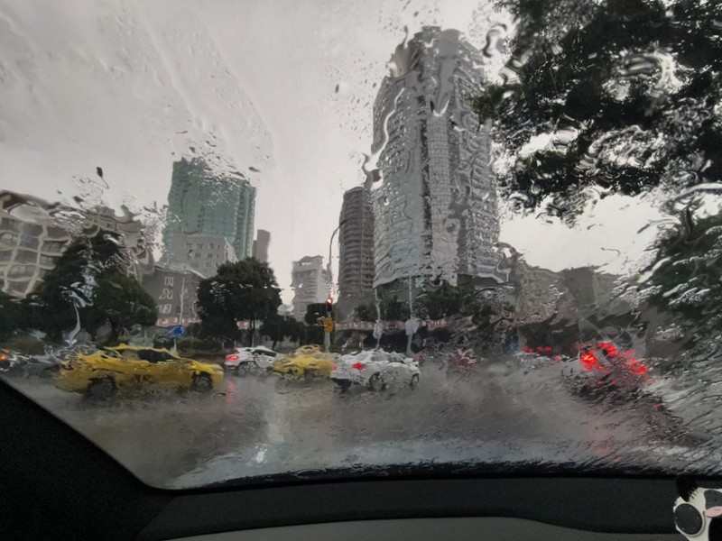 7月18日，渝中区中山四路旁环道，挡风玻璃被雨水浸润，模糊了周围建筑。记者 谢智强 摄