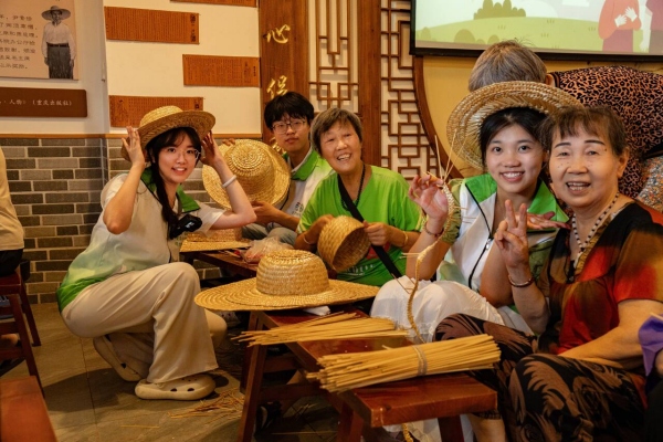 團隊成員與回龍壩鎮老人一起編織草帽。甘世杰攝