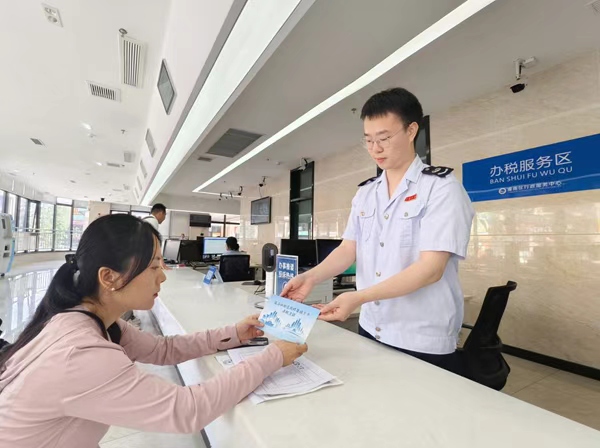潼南区税务人员为企业财务人员发放“成渝纳税信用修复提示卡”，引导其及时更正涉税失信行为。周欢摄