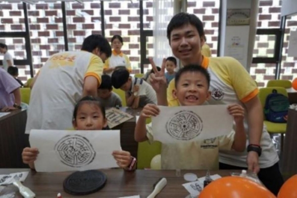 團隊成員指導小朋友體驗拓印。重慶師范大學供圖