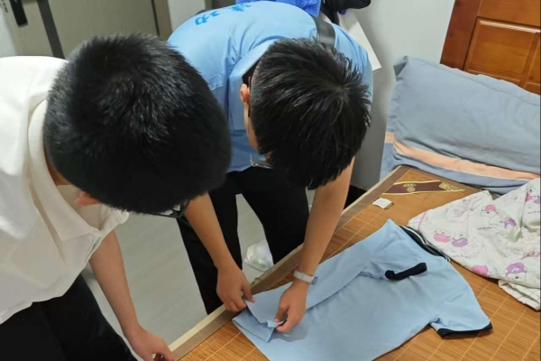 志愿者指导小朋友整理衣物。重庆理工大学供图