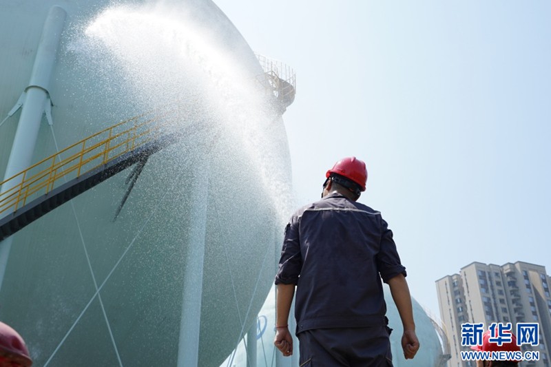 工作人員對球罐進行噴水降溫。新華網 彭浩然 攝