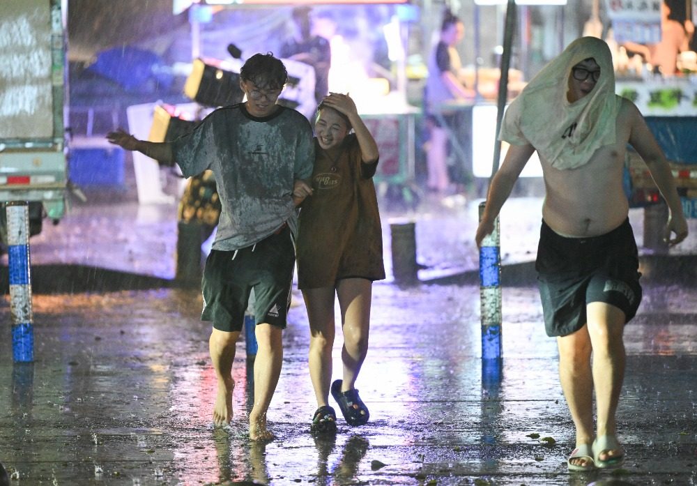 8月6日晚,南岸区水云路,市民开心地行走在暴雨中。记者 谢智强 摄