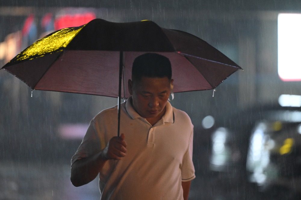 8月6日晚,南岸区水云路,市民行走在暴雨中。记者 谢智强 摄