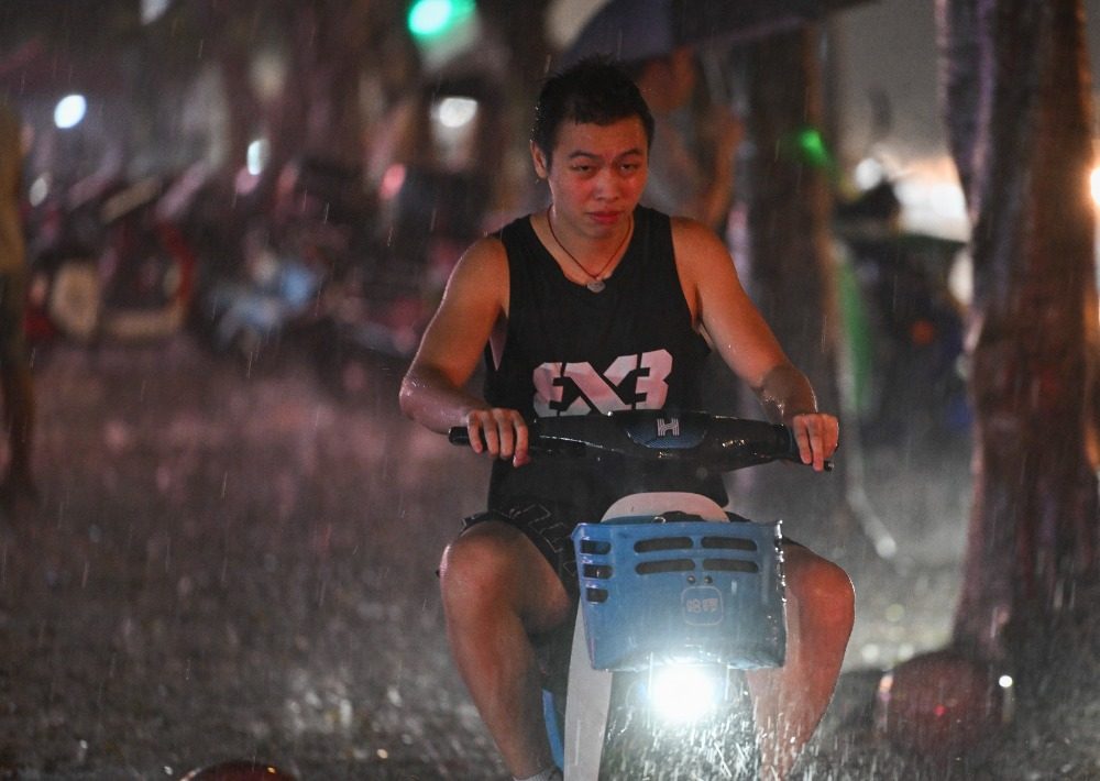 8月6日晚,南岸区水云路,市民在暴雨中骑行。记者 谢智强 摄
