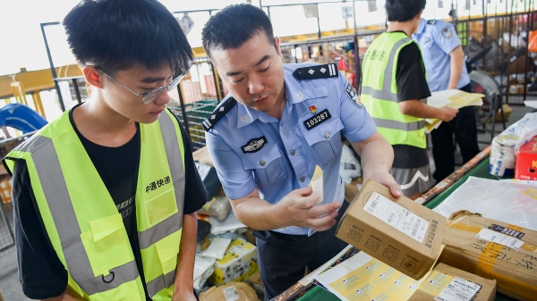 民警为快递贴上反诈宣传小贴纸。南岸区公安分局供图