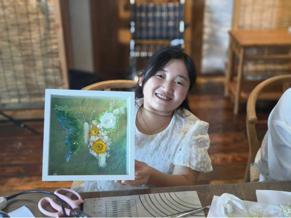 宫燕将培训中学到的永生花工艺，与毛线钩针技艺相结合，设计制作出永生花蝴蝶相框。
