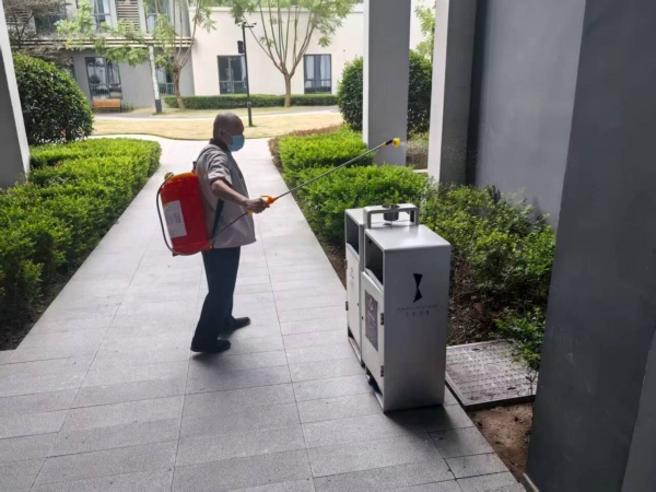 环卫人员背着消杀设备对重点部位喷洒消毒药剂。刘琴摄