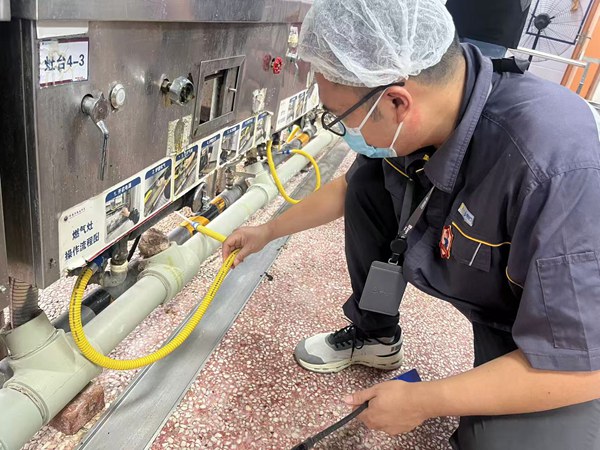 在朝阳中学南校区,检查燃气连接软管。重庆燃气集团供图