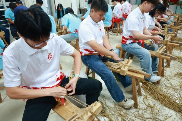 成员们体验编草鞋。重庆工商职业学院供图