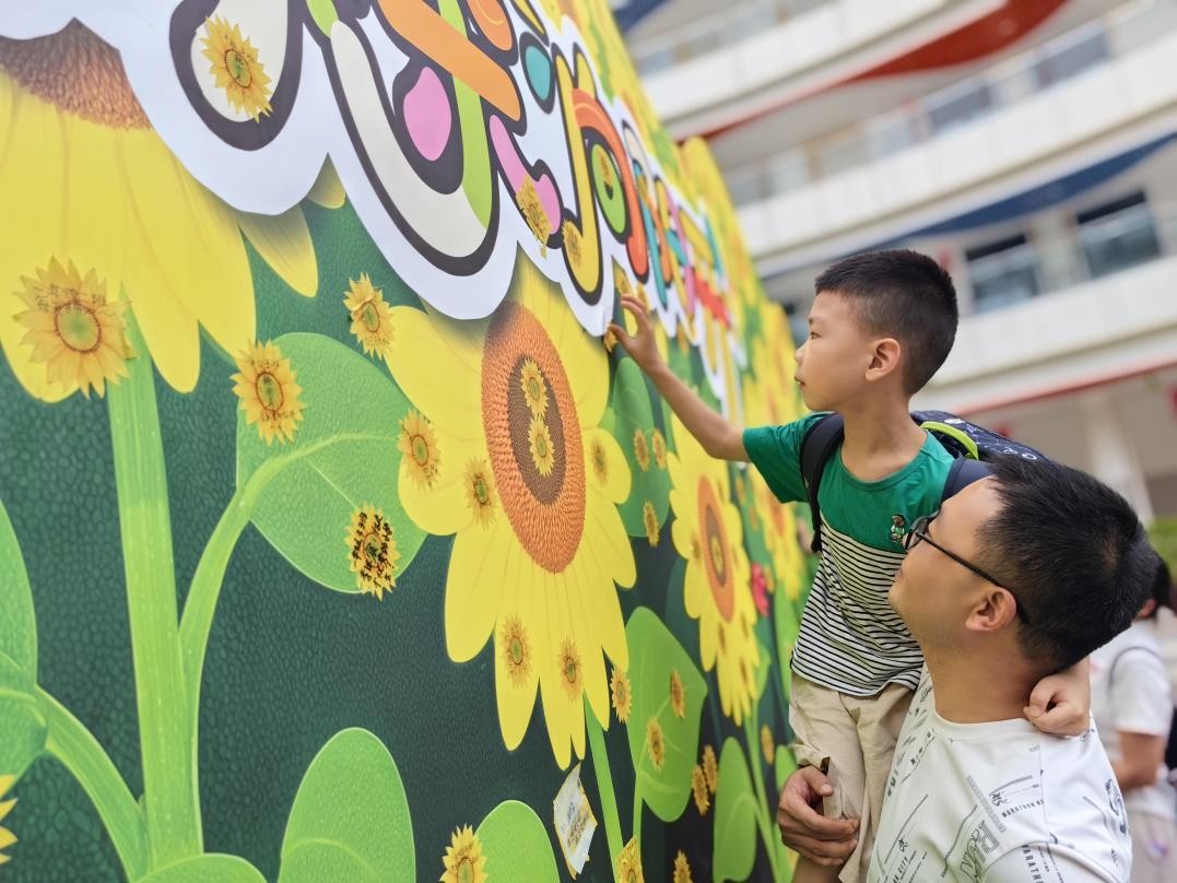 北碚区两江春晖小学一年级新生在“葵花墙”上贴上小心愿。周辉摄