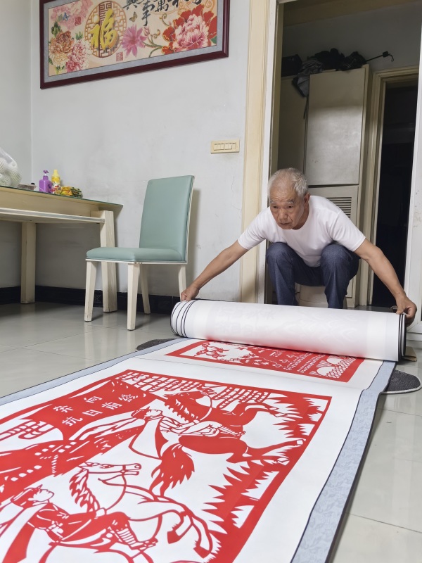 郭文友展示剪紙作品《銘記歷史 振興中華》。江津區委宣傳部供圖