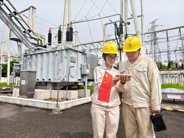 9月3日，在110千伏匯龍變電站，國網永川供電公司雷柳等人開展現場測溫工作之余，用手機收看紀念大會和閱兵儀式直播。吳京鴻攝