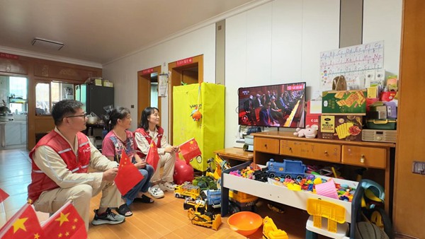 9月3日，重慶市雙橋經開區連二坡社區，國網永川供電公司雙橋供電中心員工鐘沉霞、黃洋勇等人在開展網格服務時，與居民周富強收看紀念大會和閱兵儀式直播。宋元攝