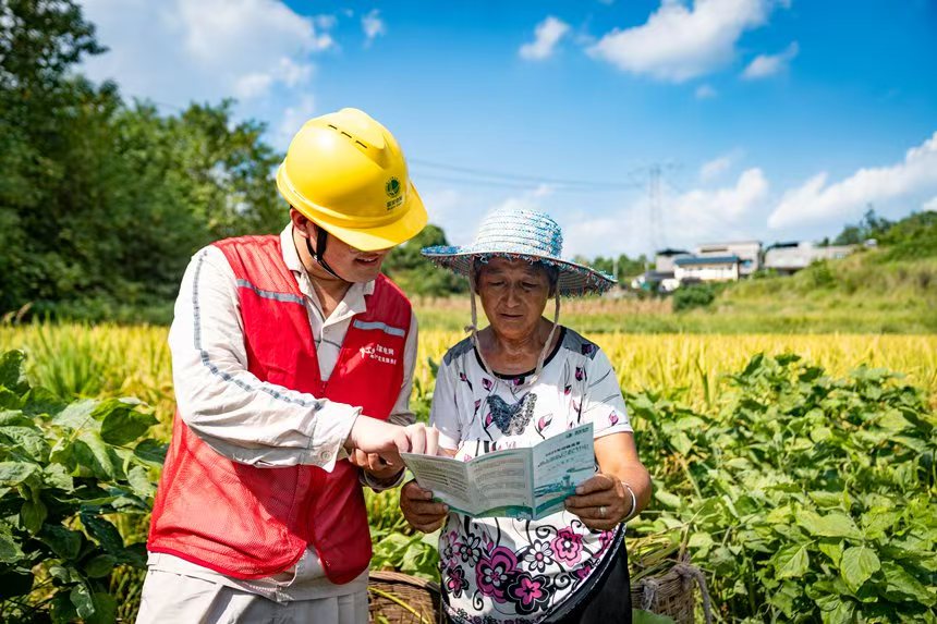 電力人員向村民介紹安全用電知識。國網永川供電公司供圖