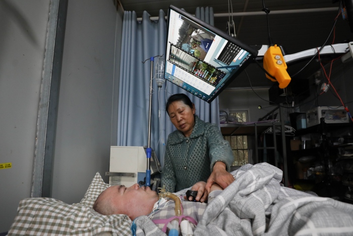 “重慶好人”黎夏用兩根指頭遙控農場的自動化系統。渝北區委宣傳部供圖