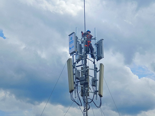 作业人员登上通信桅杆塔，进行5G-A通感一体基站安装作业。重庆移动供图