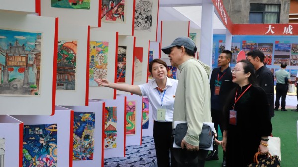 與會人員在實驗二小參觀書法作品展、社團成果展。城口縣教委供圖
