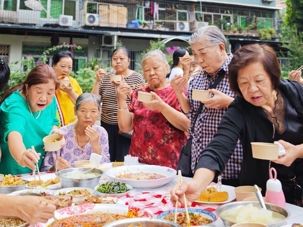 老人们享受餐食。任峰摄