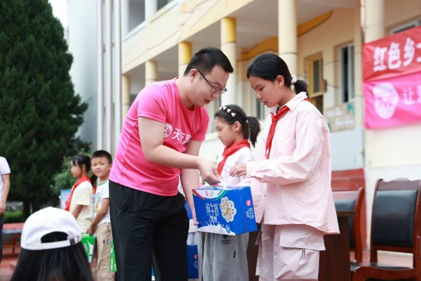 工作人員給學生捐贈牛奶。天友乳業供圖