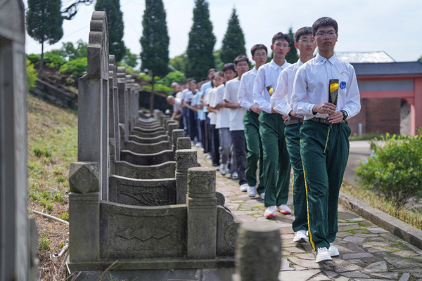 現場師生、黨員干部依次向周極明等烈士墓敬獻花。周久淞攝