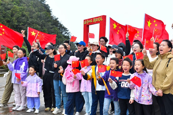 游客們揮舞國旗表達對祖國的美好祝願。景區供圖