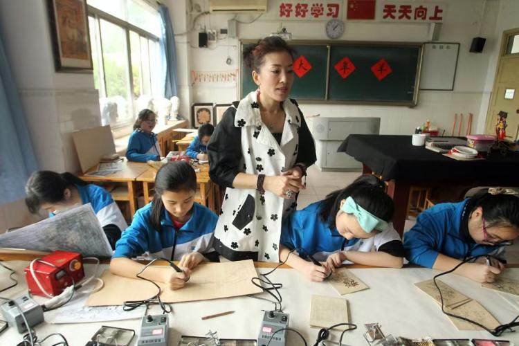 高磊老师在指导学生制作烙画。