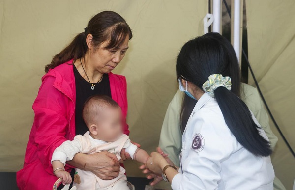 不少居民帶著孩子來到現場，體驗小兒推拿。曾英豪攝