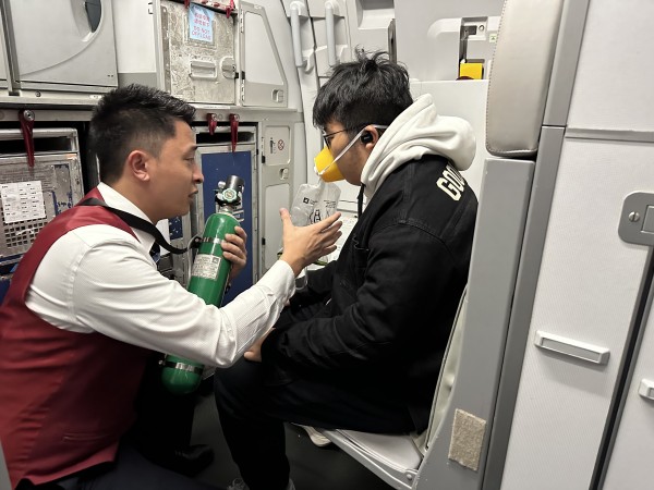 機上乘務員向旅客實施吸氧救助。重慶航空供圖