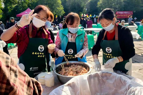 二居社区志愿者与居民一起包饺子。主办方供图