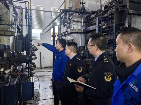 綦江區應急管理局的執法人員在綦江永躍齒輪有限公司察看設備。楊晨攝