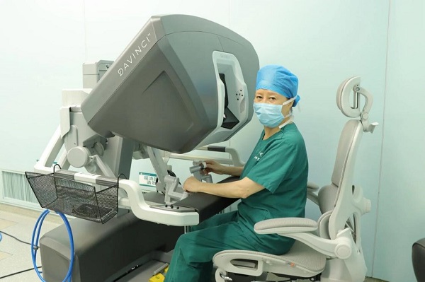 唐均英在手术机器人系统前准备进行操作。重医附属大学城医院供图