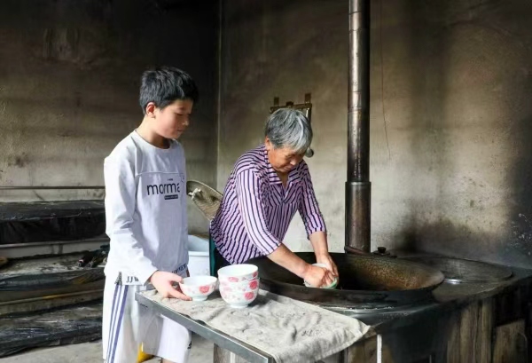 杨光辉做家务。巫溪县融媒体中心供图