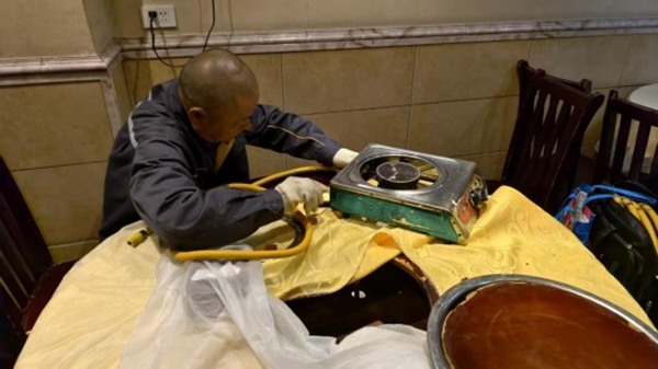 胡兵正在更換燃氣軟管。重慶燃氣集團供圖