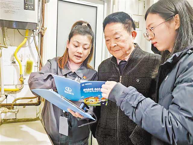 周盈盈（左一）和余秋羽为钟爷爷讲解冬季用气安全。记者 罗芸 摄/视觉重庆