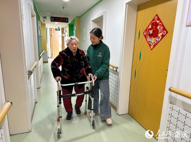 邓小梅在和行动不便的老人沟通。人民网记者 刘政宁摄