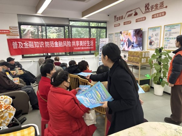 工作人员向老年朋友发放养老金融政策宣传册。兴业银行重庆分行供图