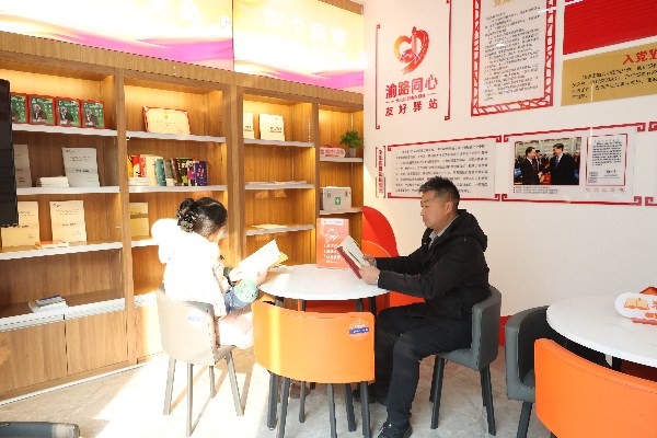 货车司机在传化公路港“渝路同心·友好驿站”翻阅书刊。郭晋摄