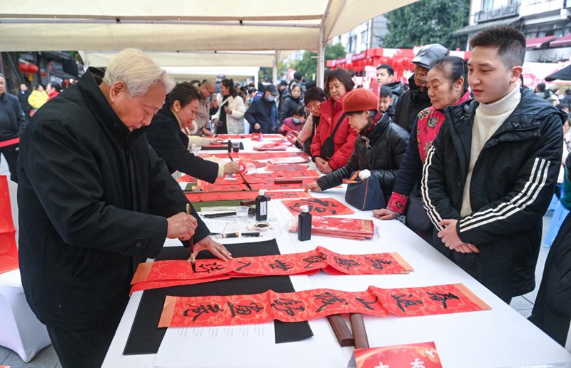 书法爱好者挥毫泼墨为市民游客写春联、送“福”字。重庆市卫健委供图