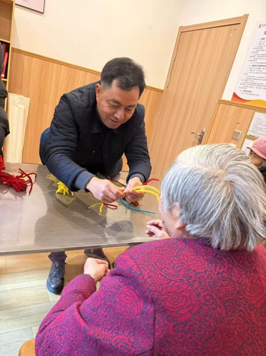 花泽伟正在教老人做手工。潘珍净摄