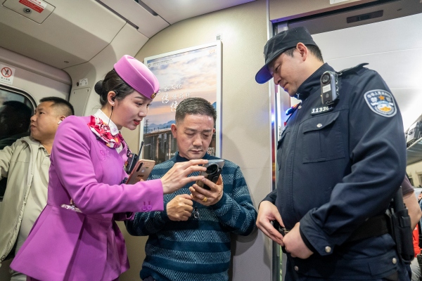 列车长和乘警在核对乘客票务信息。胡勇 摄