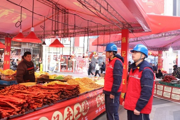 国网重庆电力（城口综合）红岩共产党员服务队队员问售卖年货商贩的用电需求。邓芝华摄