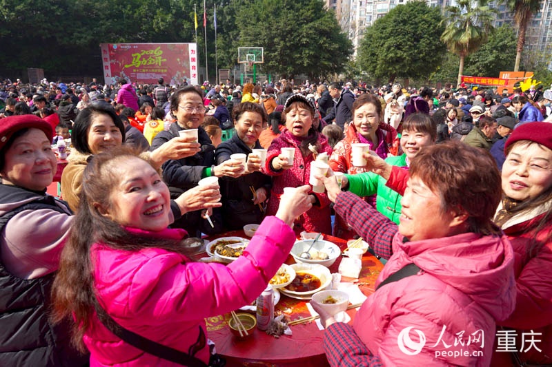 2月11日，南岸区南坪街道东路社区，居民们在“百家宴”上互祝新年快乐。人民网记者 刘祎摄