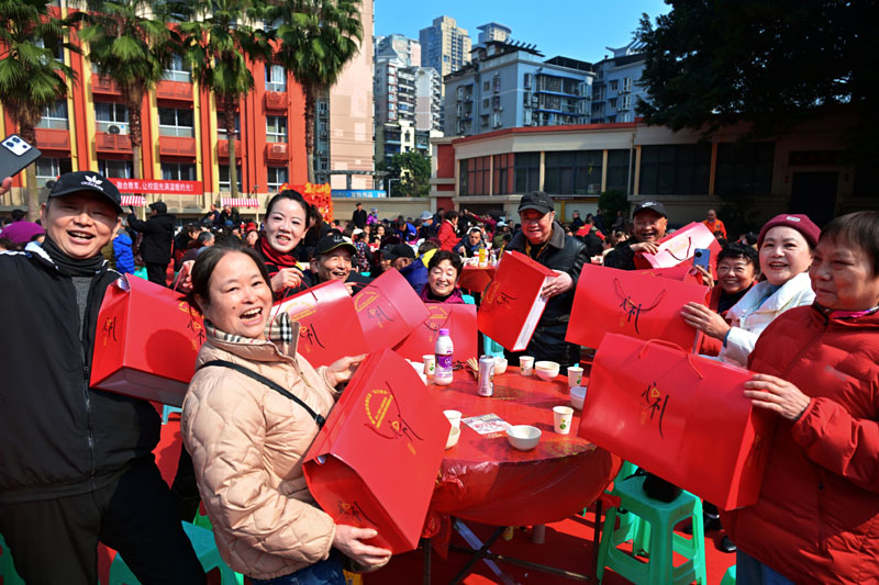 2月11日，南岸区南坪街道东路社区，居民们在“百家宴”上互祝新年快乐。